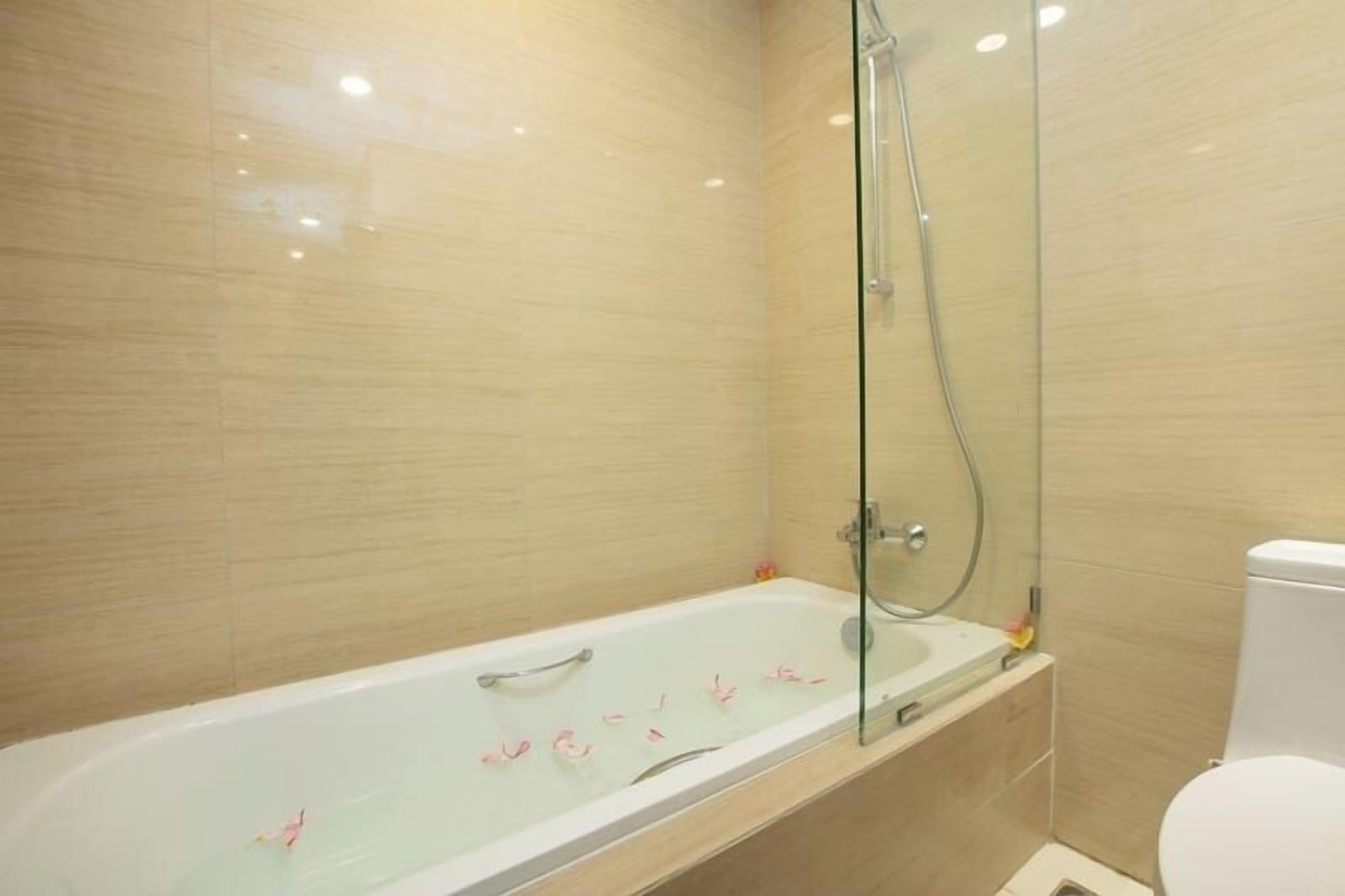 Une salle de bain moderne avec une douche à parois de verre, une baignoire blanche et des toilettes.