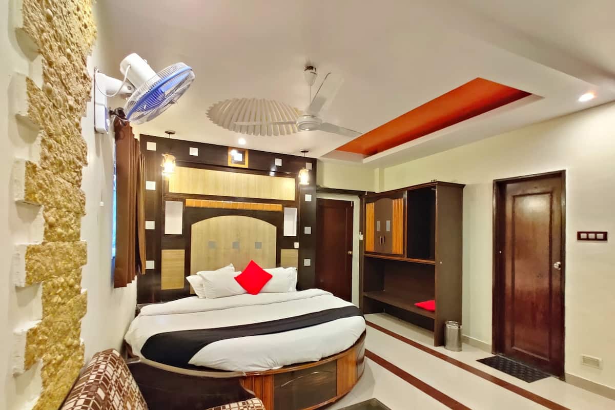 Un dormitorio con cama, armario, ventilador de techo y ventilador de pared.