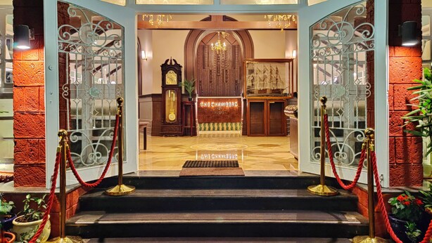 A grand entrance with a wooden door, a clock, and a sign reading "THE CHAMBERS". - Hotel Pratap Heritage (Mahabaleshwar)