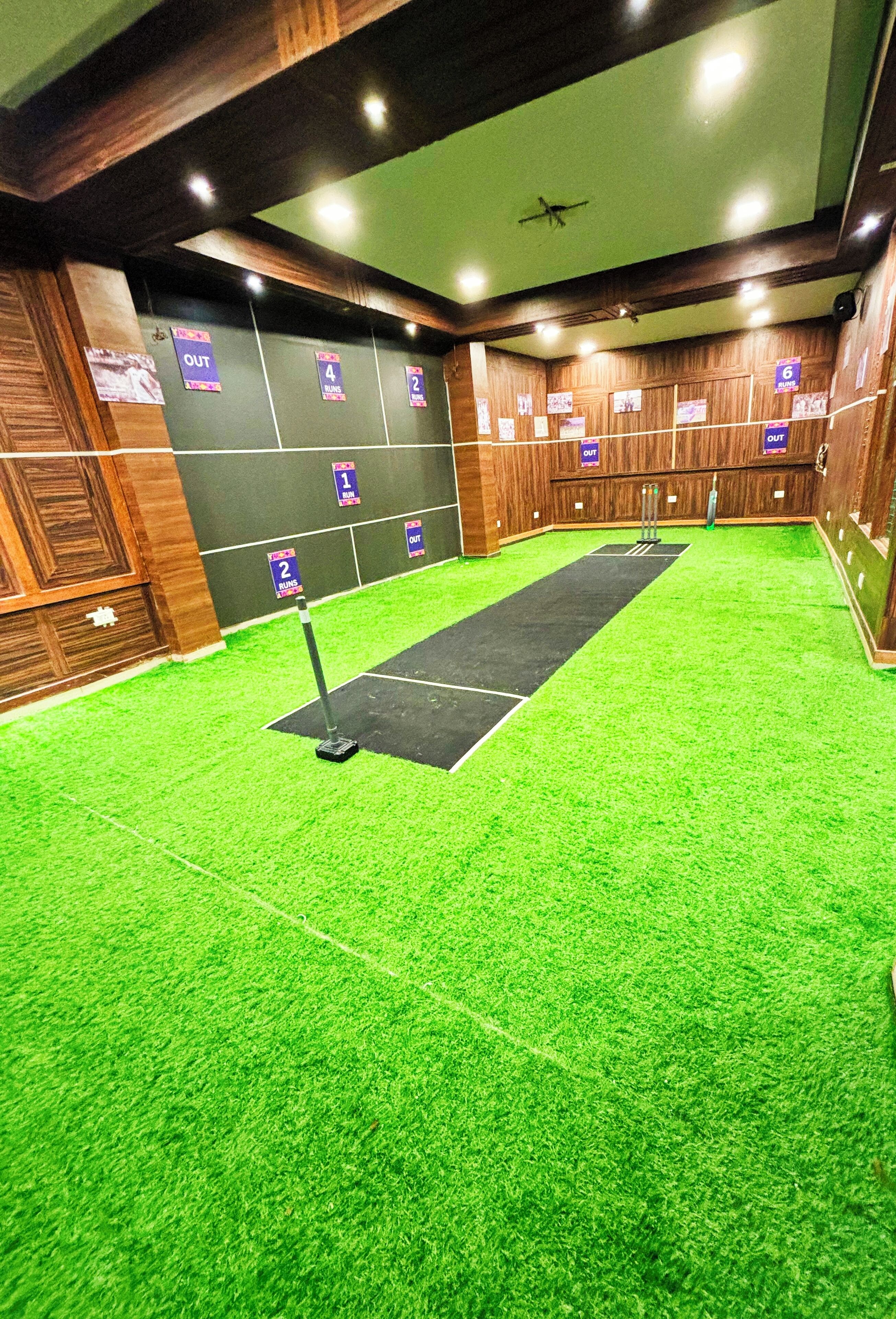 Een bowlingbaan met groen kunstgras, houten wanden en nummer genummerde banen.