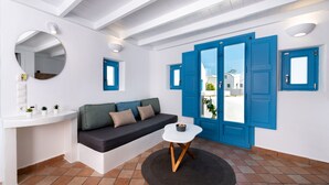 Una sala moderna con un banco blanco, un espejo redondo y puertas azules.