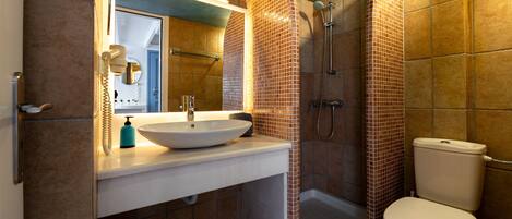 Une salle de bain avec un lavabo blanc, un miroir et des toilettes.