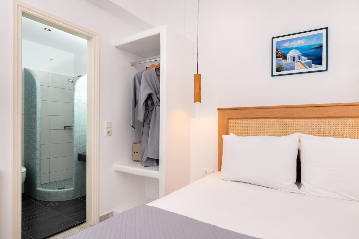 A hotel room with a bed, a shower, and a bathroom.