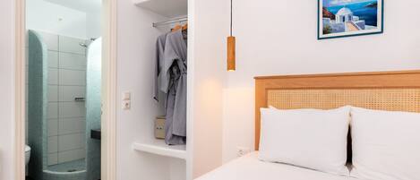 A hotel room with a bed, a shower, and a bathroom.