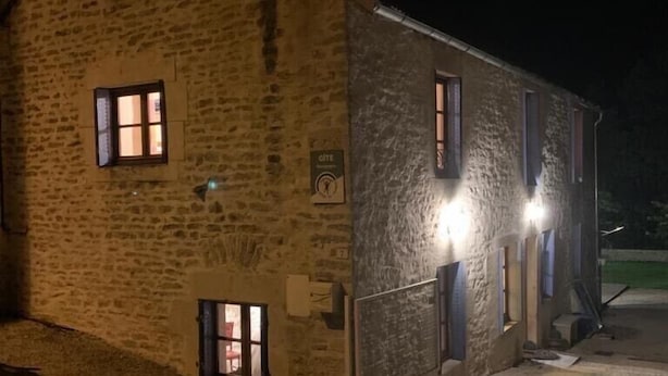 Un edificio in pietra con diverse finestre, alcune illuminate di notte.