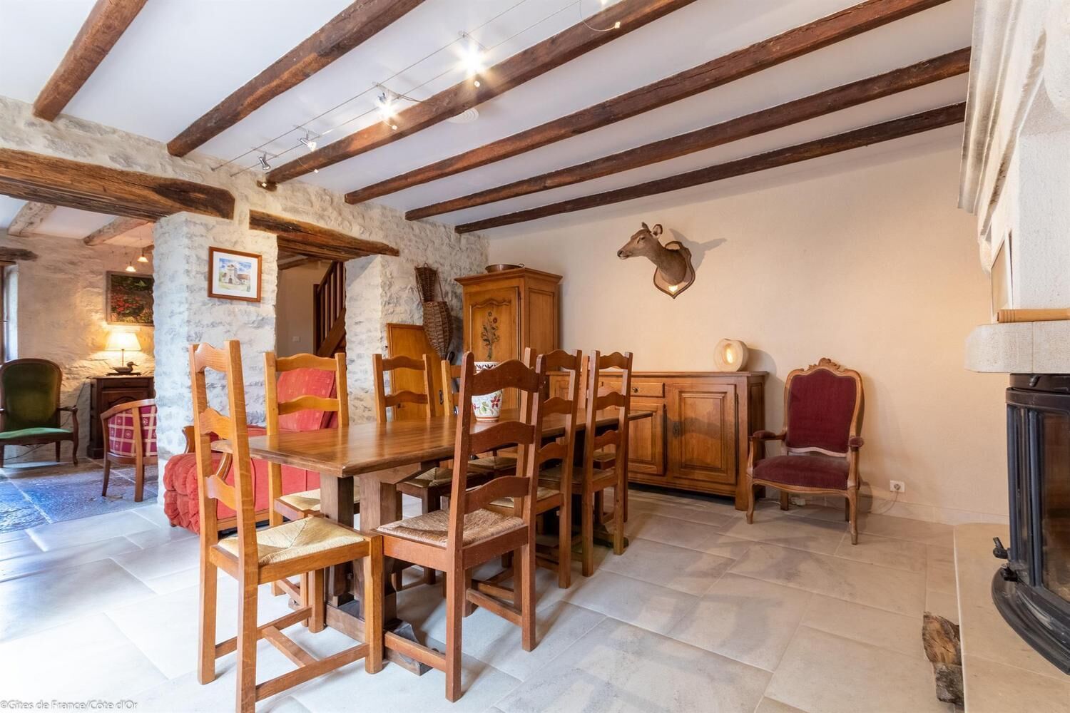 A rustic dining area with wooden furniture, stone walls, and exposed beams.