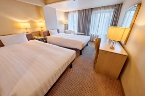Une chambre d’hôtel avec deux lits, un bureau, une chaise, une lampe et un miroir.
