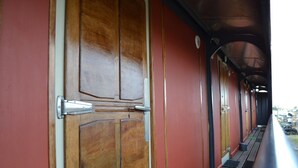 Un vagone ferroviario con porte in legno e una maniglia metallica.
