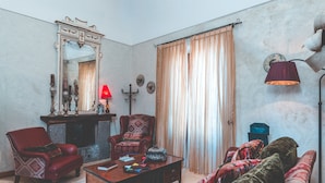 A living room with a fireplace, two armchairs, a sofa, a coffee table, and a large mirror. - Lubra Casa Relax (Massa lubrense)