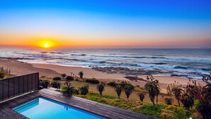 Une piscine avec vue sur l’océan et sur le coucher de soleil.