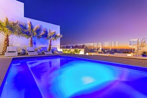 Una piscina al aire libre de temporada, tumbonas