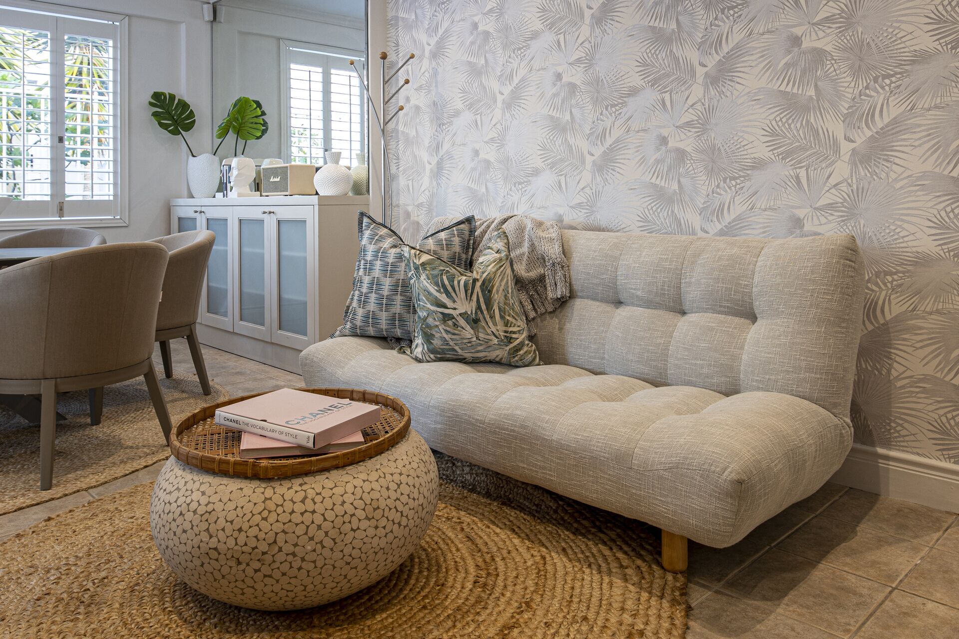 A living room with a sofa, a coffee table with a book, and a cabinet with decorative items.