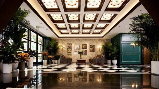 A spacious lobby with a checkered floor, large windows, and potted plants. - Yiting Zhenshe Hotel (Beijing)