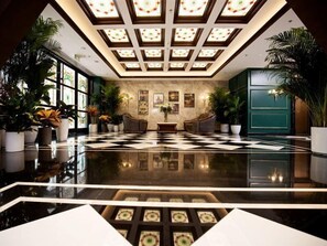 A spacious lobby with a checkered floor, large windows, and potted plants. - Yiting Zhenshe Hotel (Beijing)