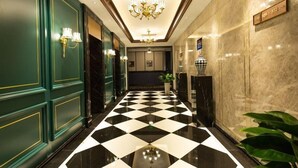 A hotel lobby with a checkered floor, green walls, and a chandelier. - Yiting Zhenshe Hotel (Beijing)