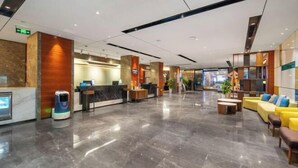 A spacious lobby with a reception desk, seating area, and a self-service kiosk. - Hampton by Hilton Fuyang Guomao (Fuyang)