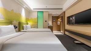 A hotel room with two beds, a large flat-screen TV mounted on the wall, a green door, and a small desk with a chair. - Hampton by Hilton Fuyang Guomao (Fuyang)