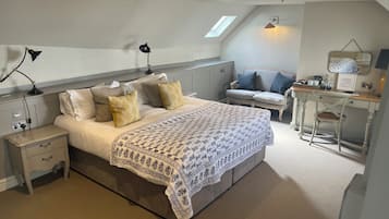 Un dormitorio con cama, mesitas de noche, escritorio y una silla.
