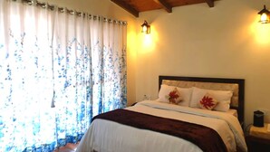 Une chambre à coucher avec un lit, des rideaux et des lampes fixées au mur.