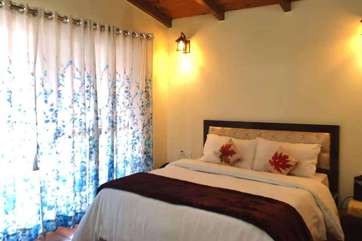 Ein Schlafzimmer mit Bett, Vorhängen und Wandleuchten.
