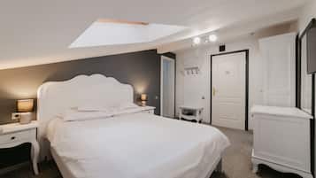 Relax in a spacious room with a large bed, nightstand, and wardrobe, featuring a skylight for natural illumination.