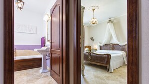 Ein Schlafzimmer mit einem Bett, einem Nachttisch, einem Schminktisch mit Spiegel und einer Chandelier.