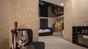 A hotel room with a bed, a seating area with a table, and a glass cabinet. - Boutique Hotel Madison  (Belgrade)