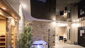 A modern hotel lobby with a large bathtub, a staircase, and a plant. - Boutique Hotel Madison  (Belgrade)