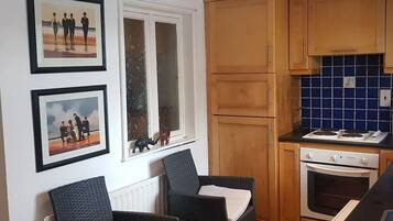 A kitchen with wooden cabinets, a stove, and a window with a view of the outside.