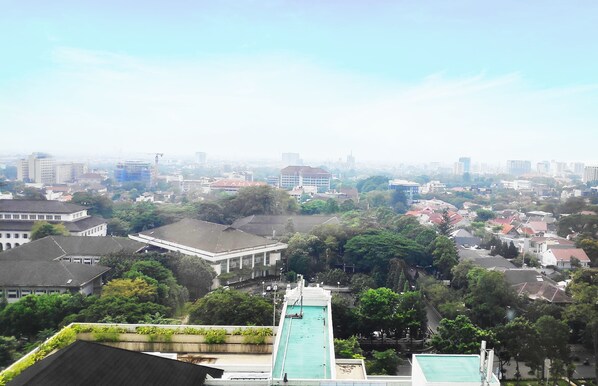 A cityscape with a swimming pool in the foreground, surrounded by buildings and greenery. - ibis Styles Bandung Grand Central (Bandung)