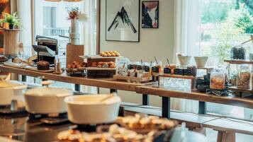 A buffet setup with various food items and condiments.