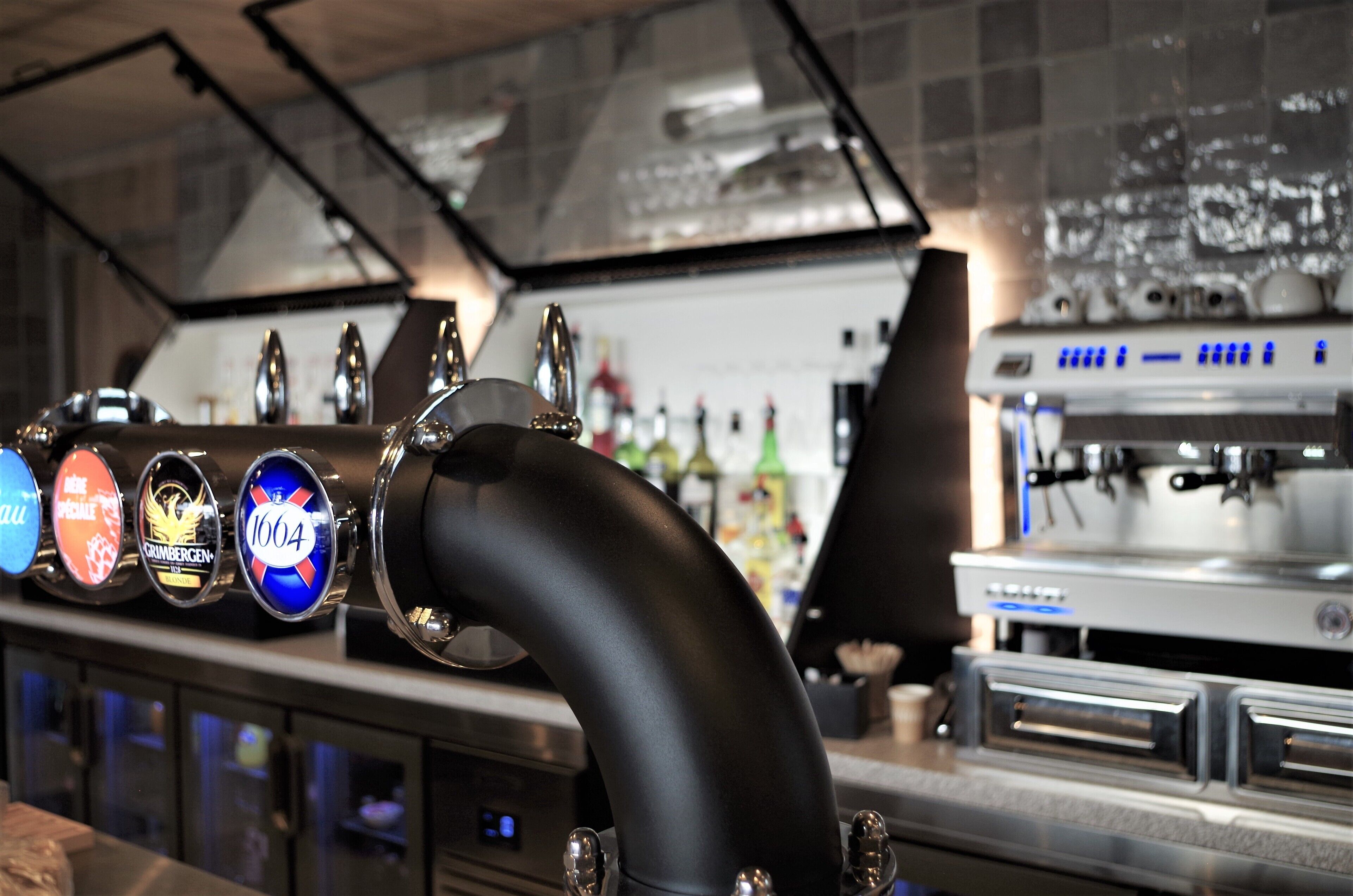 Una zona de bar con grifo de cerveza y máquina de café.