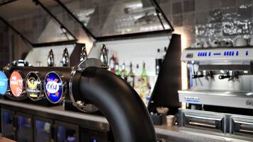 Una zona de bar con grifo de cerveza y máquina de café.