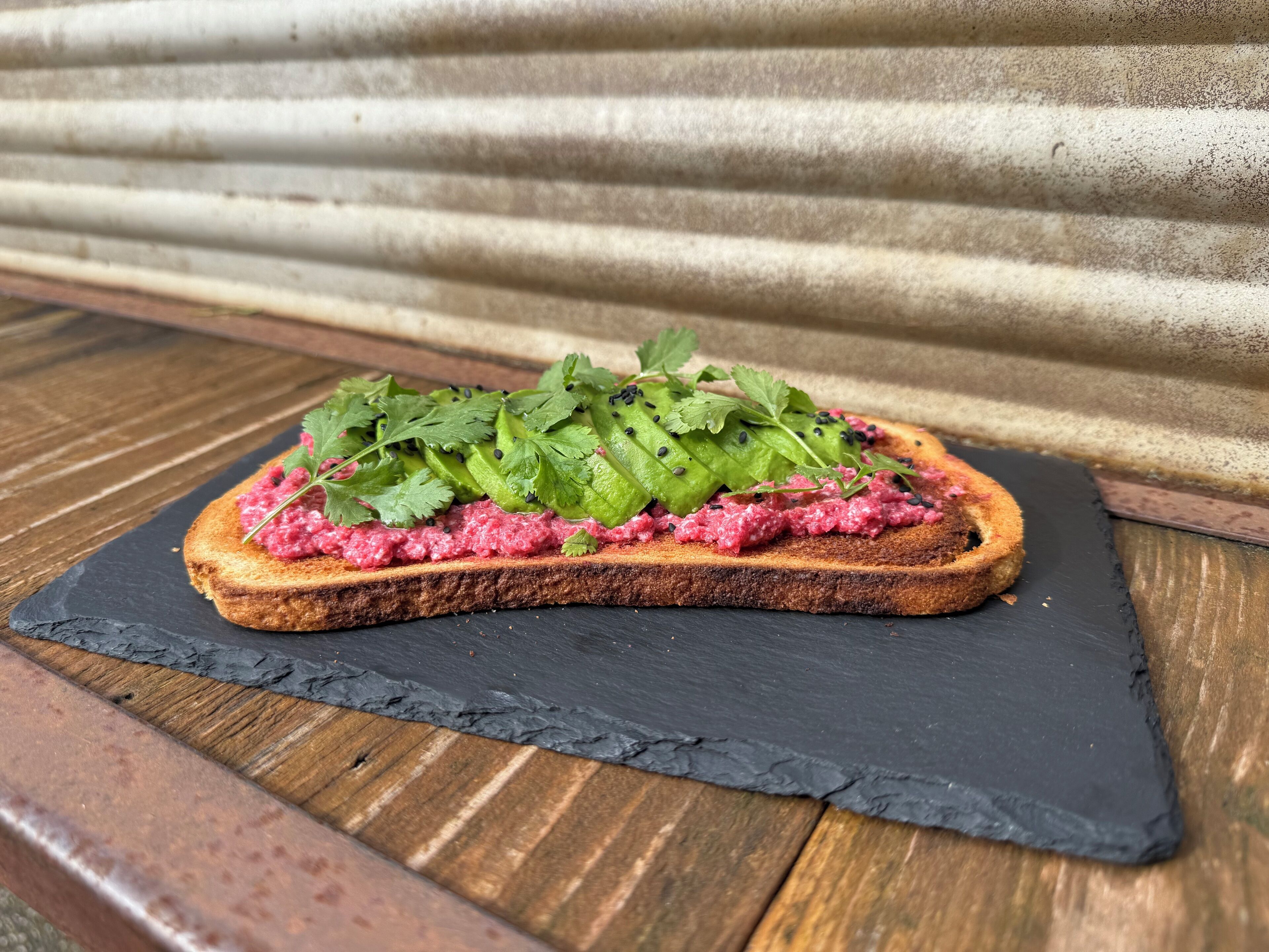 Un sandwich servi sur une planche d’ardoise.