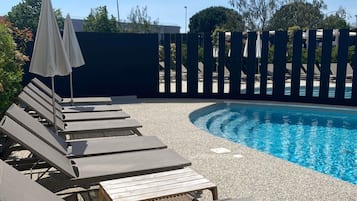 Alberca al aire libre por temporada y sombrillas en la alberca