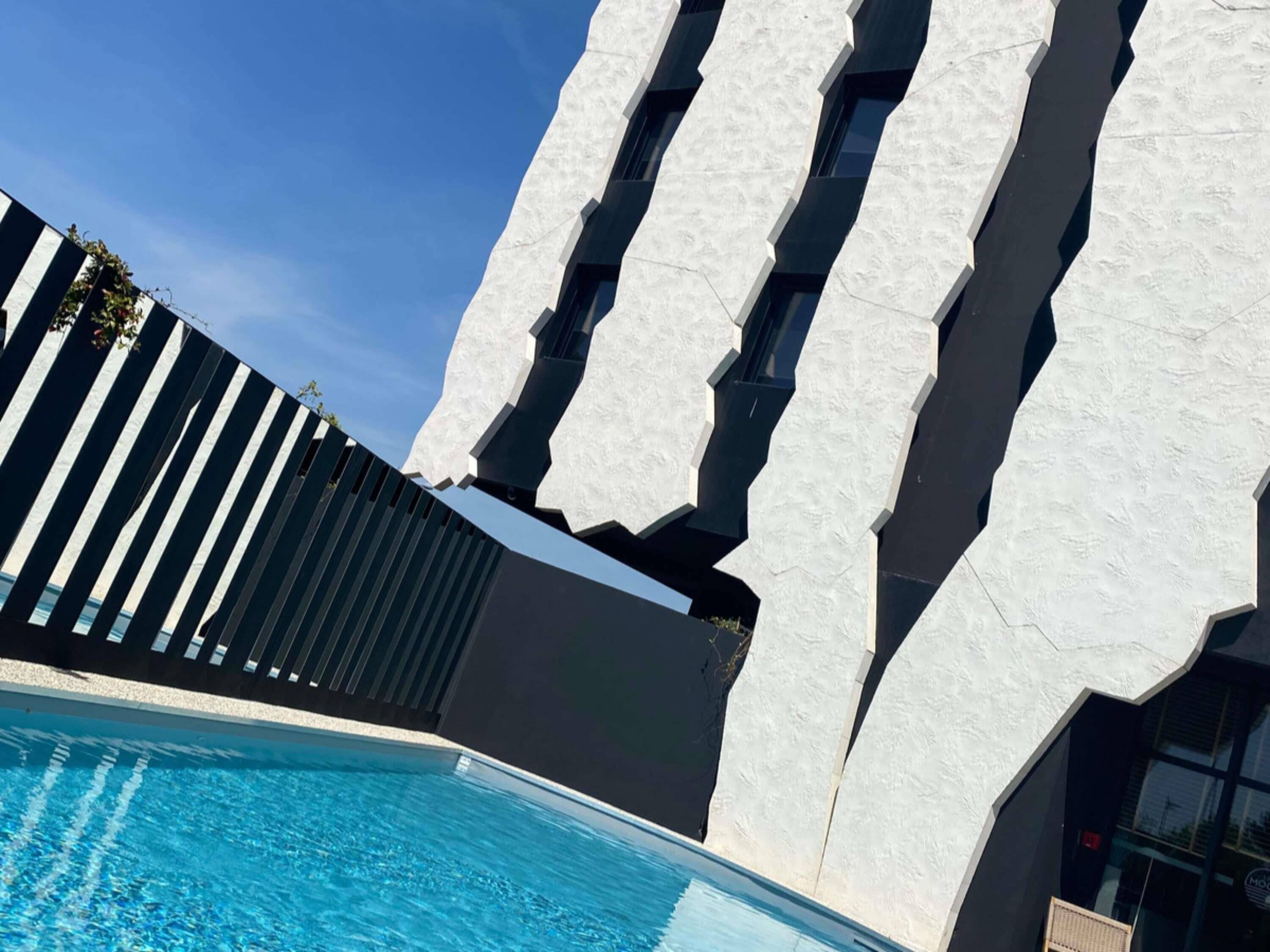 Una piscina al aire libre de temporada, sombrillas, tumbonas