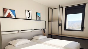 A hotel room with two beds, a large window, and artwork on the wall. - Ibis Lunel Petite Camargue (Lunel)