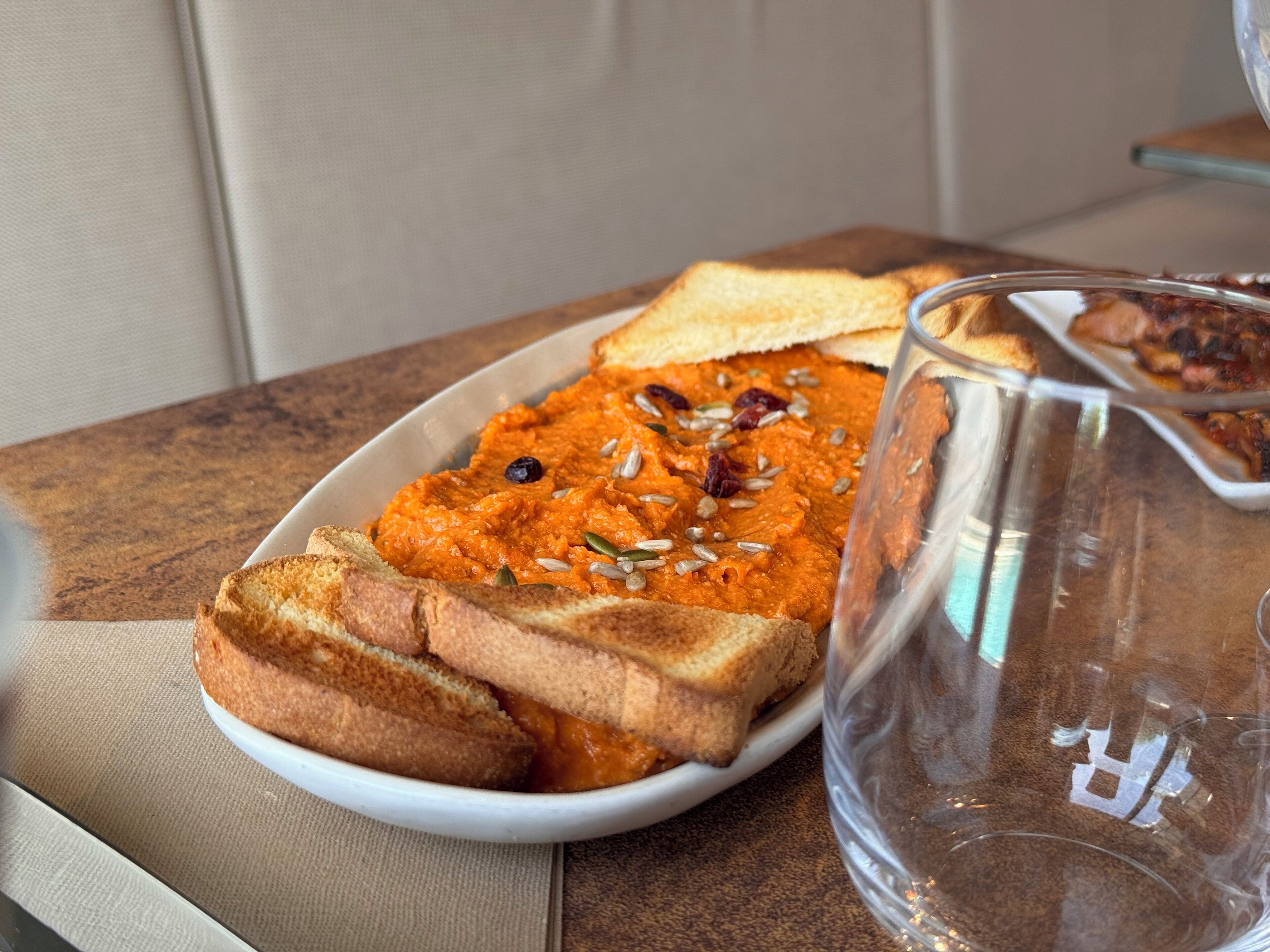 A plate of food with bread and a glass pitcher.