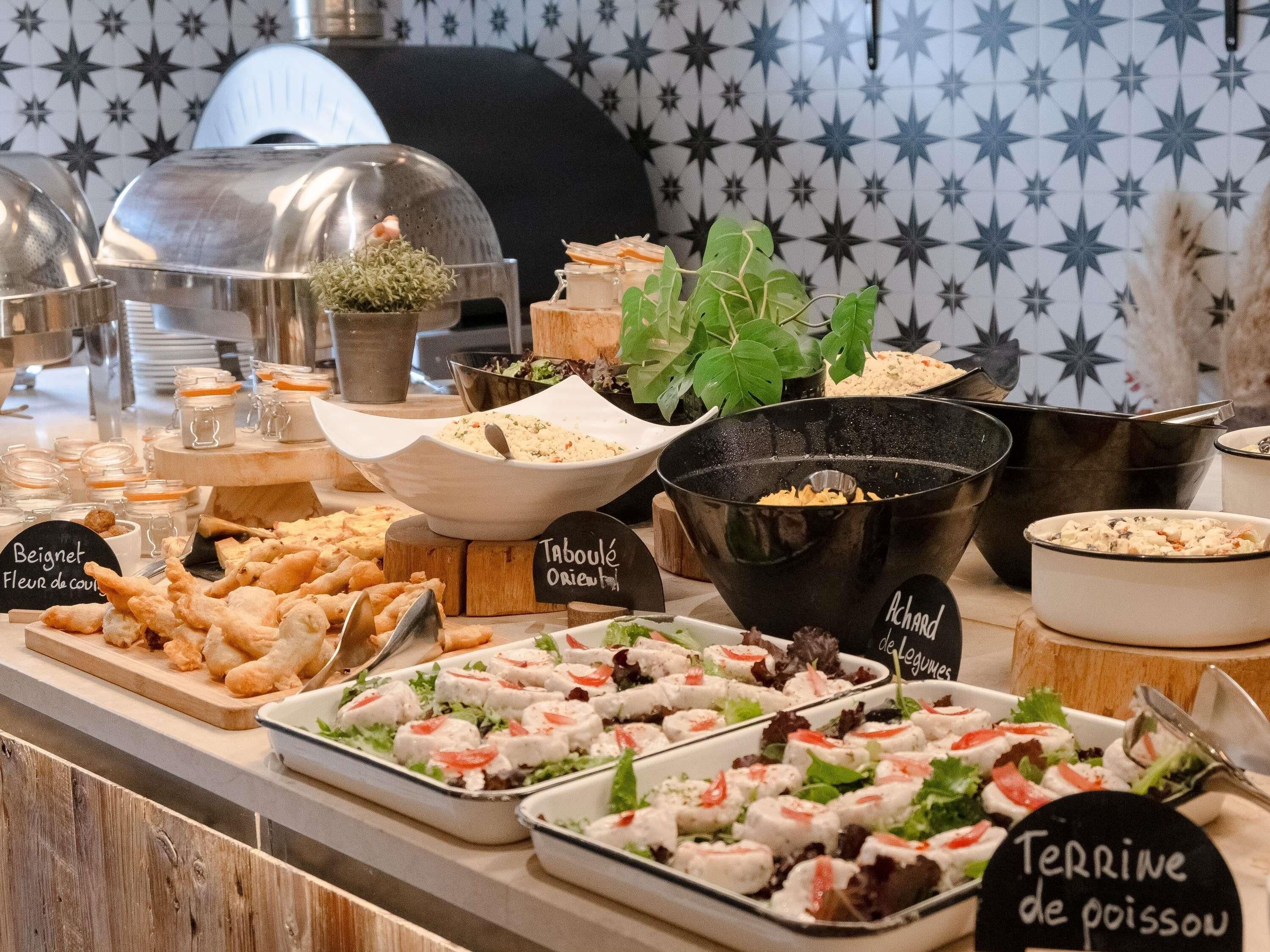 A buffet with various food items including salads, bread, and a grill station.