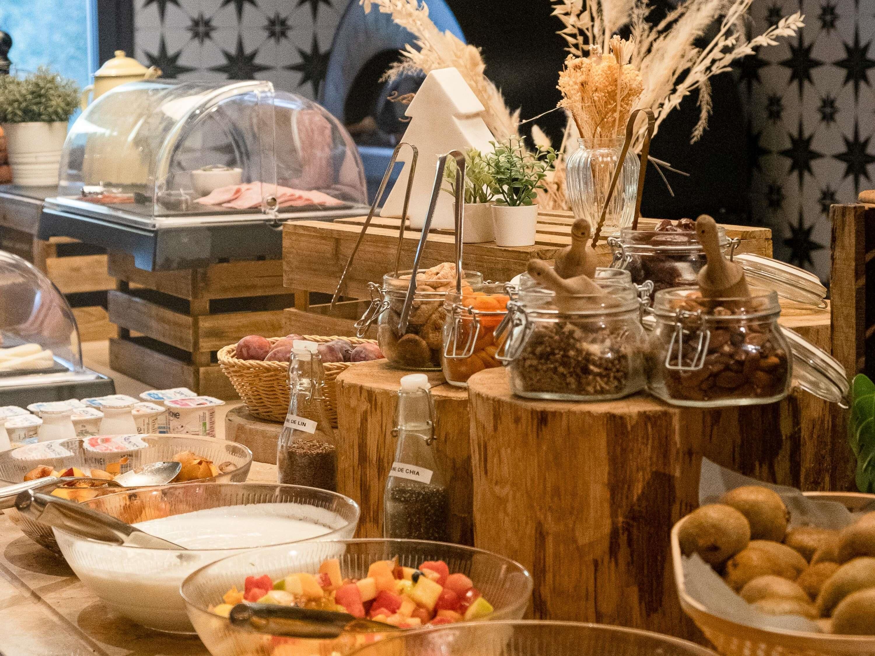 Un bufé con diferentes opciones de comida, incluyendo frutas, nueces y salsas.