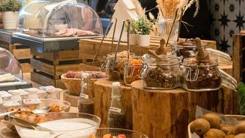 Un bufé con diferentes opciones de comida, incluyendo frutas, nueces y salsas.