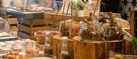 Un bufé con diferentes opciones de comida, incluyendo frutas, nueces y salsas.