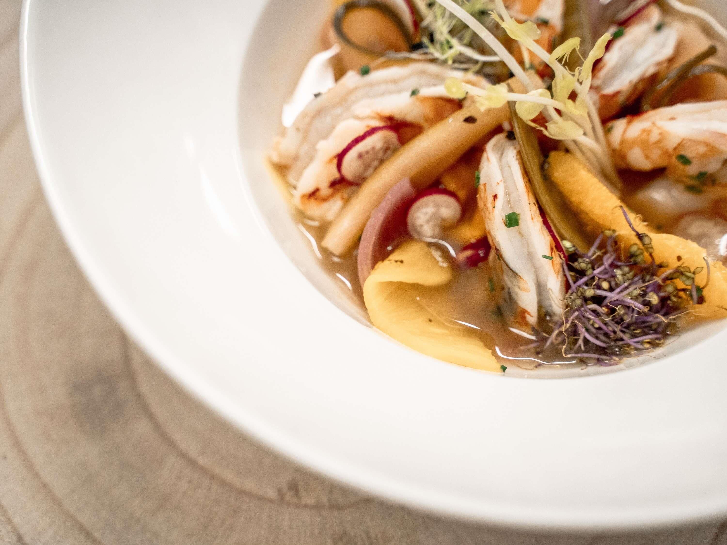 Un bol de sopa de mariscos con diversos ingredientes.