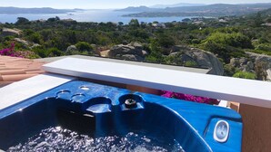 A hot tub with a view of a coastal landscape.
