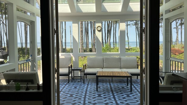 A sunlit room with a patterned floor, a sofa, and a table.