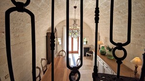 A spacious dining area with a high ceiling and a chandelier, leading to a kitchen area with modern appliances and a view of the outdoors. - Trullo Don Mino, near Alberobello and Locorotondo, private pool (Locorotondo)
