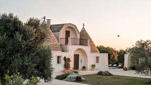 A stone building with a turreted roof, arched doorways, and a balcony. - Trullo Don Mino, near Alberobello and Locorotondo, private pool (Locorotondo)