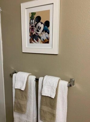 Bathroom features a bathtub and a towel rack with two towels.