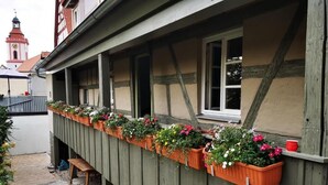 A building with a balcony adorned with flower boxes. - RefuKium 'Alte Brennerei' in the center of Weißenburg (Weißenburg in Bayern)