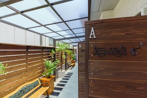 Welcome to a warm and inviting entrance, featuring a sign with separate sections, a decorative welcome sign, and a seating area with planters.